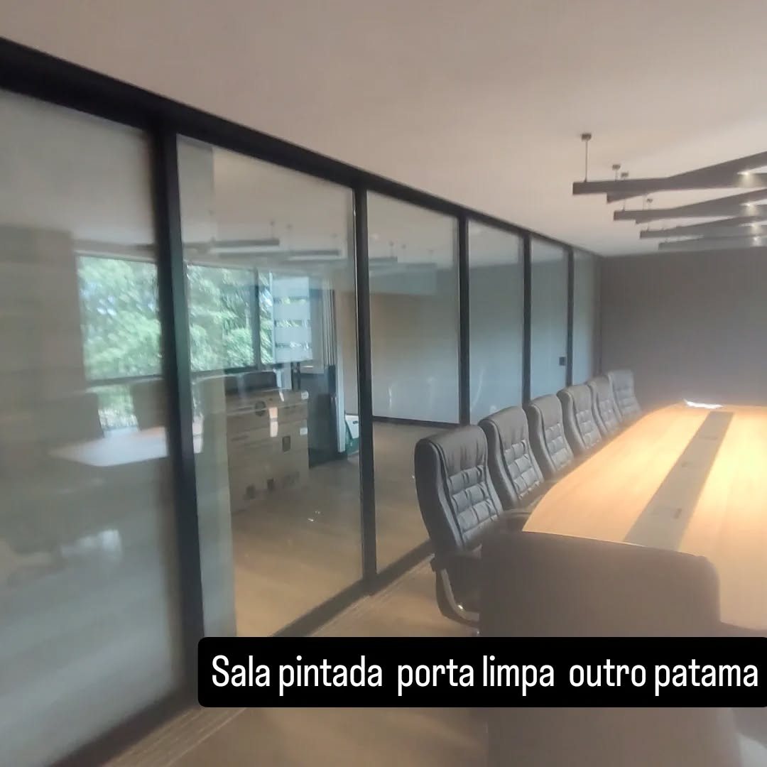 Sala de reunião com divisórias de vidro e porta de correr em alumínio preto